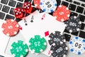 Online poker casino theme. Gambling chips with dice and playing cards on laptop Royalty Free Stock Photo