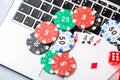 Online poker casino theme. Gambling chips with dice and playing cards on laptop Royalty Free Stock Photo