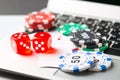 Online poker casino theme. Gambling chips with dice and playing cards on laptop Royalty Free Stock Photo