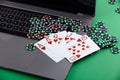 Online poker casino theme. Gambling chips, playing cards anf laptop on green background Royalty Free Stock Photo