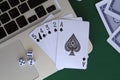 Online poker games. black straight flush of spades with laptop and dice on the green.