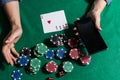 online poker player with a smartphone at a casino table with cards and chips. Royalty Free Stock Photo