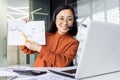 Online presentation remote meeting, asian woman with headset phone smiling and showing to laptop camera graph for good Royalty Free Stock Photo
