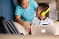 Online remote learning and homeschooling education concepts. School kid Asian preteen boy in headphone using laptop computer