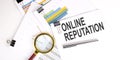 ONLINE REPUTATION text on white paper on the light background with charts paper Royalty Free Stock Photo