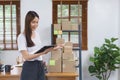 Online selling concept, Asian business women reads customer data and checks online order on tablet