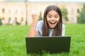 Online shop. happy blogging. girl sitting on green grass with laptop. Start up. child playing computer game. back to Royalty Free Stock Photo