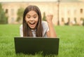 Online shop. happy blogging. girl sitting on green grass with laptop. Start up. child playing computer game. back to Royalty Free Stock Photo