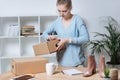 online shop proprietor with cardboard boxes working