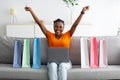 Online shopping. Black woman with credit card and laptop buying something via internet at home, making YES gesture Royalty Free Stock Photo