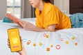 Online shopping. Close up of young woman is lying on the bed and reading a magazine. Hand with smartphone with grocery cart and Royalty Free Stock Photo