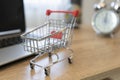 Online shopping concept. Shopping cart, laptop on the desk