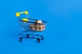 Online shopping concept. Shopping cart with small boxes inside on blue background. Shop sales, black friday concept