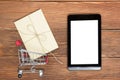 Online shopping concept - Empty Shopping Cart, laptop and tablet pc, gift box on rustic wooden background Royalty Free Stock Photo