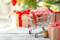 Online shopping concept - full Shopping Cart and gift boxes. Trolley full of different Christmas gift boxes with red ribbon on