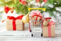 Online shopping concept - full Shopping Cart and gift boxes. Trolley full of different Christmas gift boxes with red ribbon on