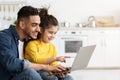 Online Shopping Concept. Happy Arab Dad And Little Daughter Using Laptop Together Royalty Free Stock Photo