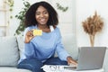 Black woman using laptop and showing credit card Royalty Free Stock Photo