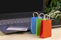 online shopping . little shopping cart, boxes, colorful bags, bank card, dollars stand on laptop Royalty Free Stock Photo