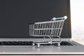 Online shopping concept with mini trolley store on laptop keyboard