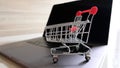 Online shopping concept. Shopping cart, laptop on the desk. Royalty Free Stock Photo