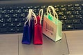 Online shopping concept, Three colorful paper shopping bags on notebook keyboard. E-commerce is the purchase of products and servi Royalty Free Stock Photo