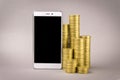 Online shopping concept. white smartphone, and coins on a gray background Royalty Free Stock Photo