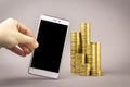 Online shopping concept. white smartphone, and coins on a gray background Royalty Free Stock Photo