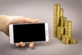 Online shopping concept. white smartphone, and coins on a gray background Royalty Free Stock Photo