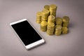 Online shopping concept. white smartphone, and coins on a gray background Royalty Free Stock Photo