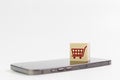 Online shopping concept. wood cube block with shopping cart icons over on mobile phone, use smartphone connection marketplace Royalty Free Stock Photo