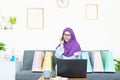 Online shopping concept,Young asian muslim woman in traditional dress wearing glasses with laptop making online shopping and many Royalty Free Stock Photo