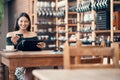 Online shopping with a credit card at a cafe by a trendy woman browsing on a tablet with earphones and paying for her Royalty Free Stock Photo