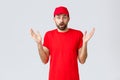 Online shopping, delivery during quarantine and takeaway concept. Confused and shocked courier in red t-shirt and cap of