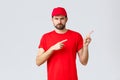 Online shopping, delivery during quarantine and takeaway concept. Displeased angry courier in red uniform cap and t