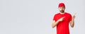 Online shopping, delivery during quarantine and takeaway concept. Displeased angry courier in red uniform cap and t