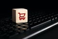 Online shopping and e-commerce concept with shopping cart icon on wooden cube on computer keyboard Royalty Free Stock Photo