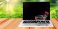 Online shopping and e-commerce concept. Trolley on laptop keyboard on screen with natural background. Consumer buy product directl Royalty Free Stock Photo