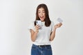 Online shopping and ecommerce. Happy young woman using mobile phone and holding plastic credit card, making purchase Royalty Free Stock Photo