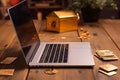 Online shopping with a gold card and a laptop, hand on a wooden table