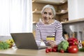 Online Shopping. Happy Elderly Lady Using Laptop And Credit Card In Kitchen Royalty Free Stock Photo