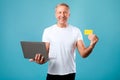 Excited mature man holding credit card and laptop Royalty Free Stock Photo