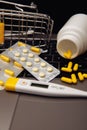 Online shopping with home delivery. Trolley with pills on laptop keyboard and medical tools. Vertical image