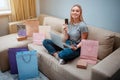 Online shopping at home. Young happy shopper with credit cards is choosing best sale of Singles day while sitting on a