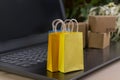 online shopping . little shopping cart, boxes, colorful bags, bank card, dollars stand on laptop Royalty Free Stock Photo