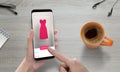 Online shopping with modern mobile phone. Woman use online store to buy pink dress Royalty Free Stock Photo