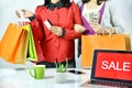 Online shopping order, Shopaholic women friends holding money cash and credit card, Sale promotion banner sign on laptop computer.