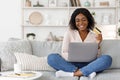 Online Shopping. Positive Black Girl Using Laptop and Credit Card At Home