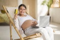 Online Shopping. Pregnant Woman With Laptop And Credit Card Relaxing In Chair Royalty Free Stock Photo