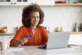 Online Shopping. Smiling Black Woman Using Credit Card And Laptop In Kitchen Royalty Free Stock Photo